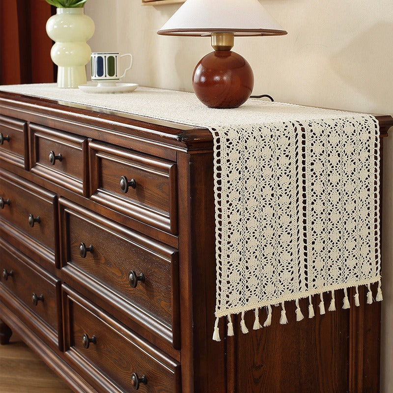 Beige crochet table runner on a wooden table