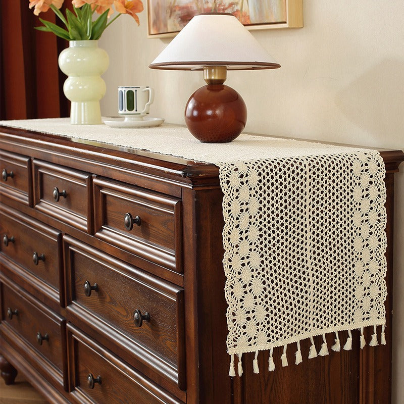 Beige crochet table runner on a wooden table