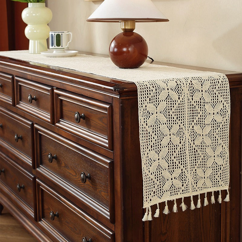 Beige crochet table runner on a wooden table