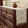 Beige crochet table runner on a wooden table