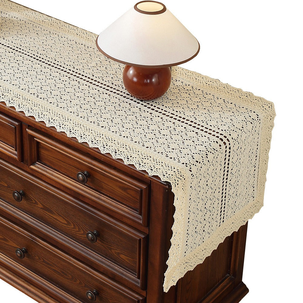 Beige crochet table runner on a wooden table