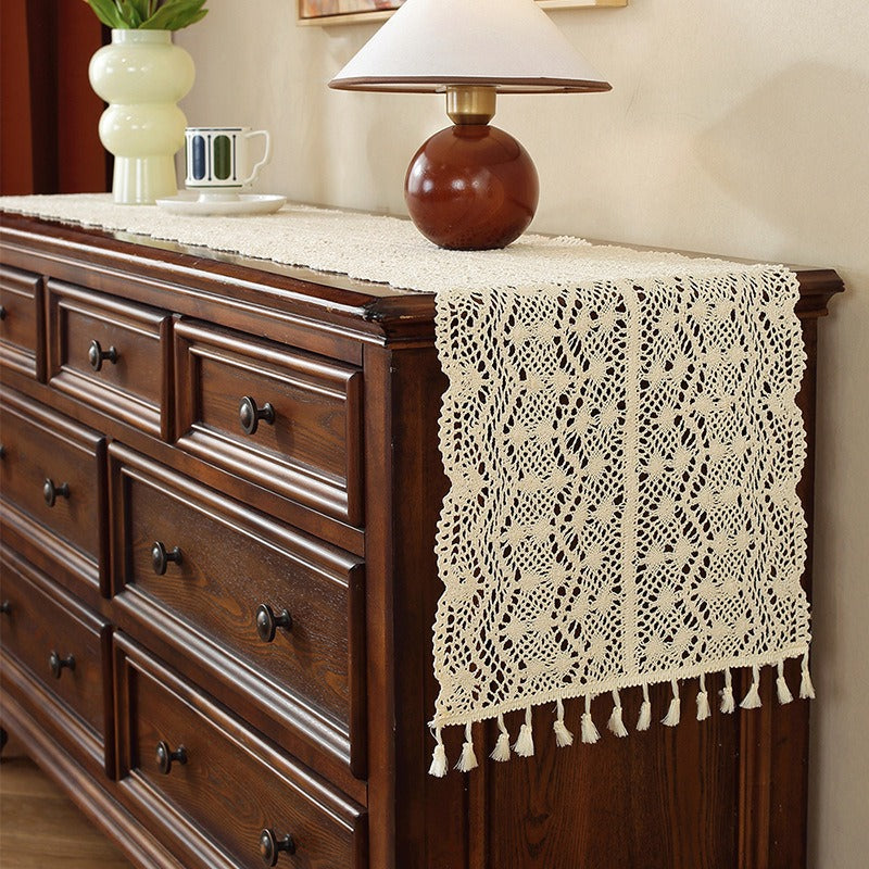 Beige crochet table runner on a wooden table