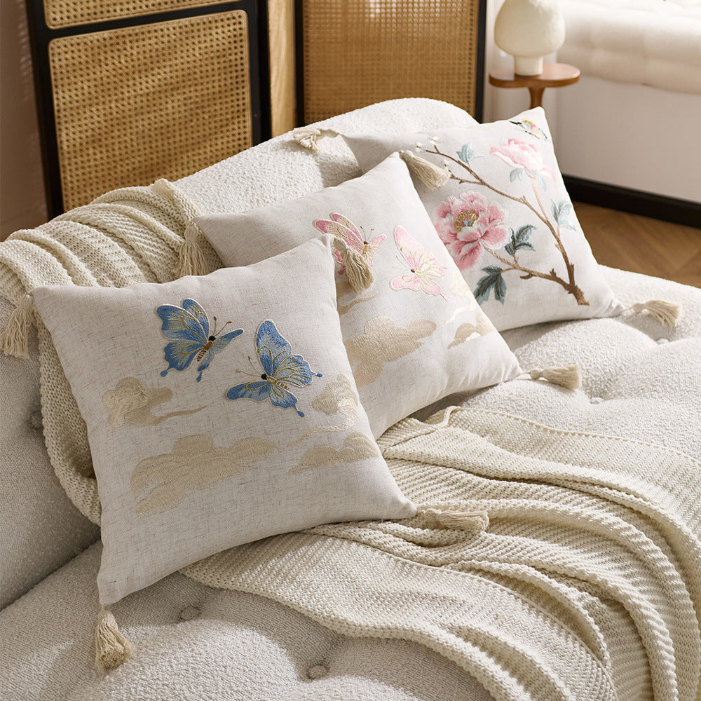 Embroidered cushion cover with tassels on a sofa