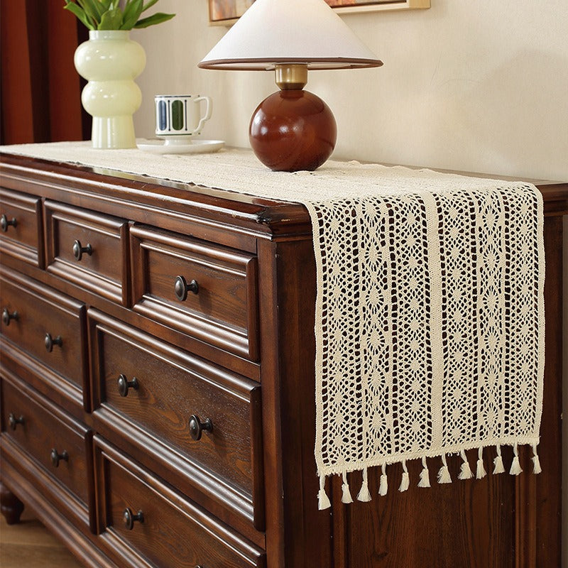Beige crochet table runner on a wooden table